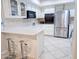 Bright kitchen featuring white cabinets, stainless steel fridge and microwave at 17404 N 99Th Ave # 126, Sun City, AZ 85373