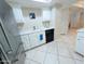 Bright kitchen features white cabinets, stainless steel refrigerator, and a skylight for natural light at 17404 N 99Th Ave # 126, Sun City, AZ 85373