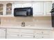 All-white kitchen with microwave, overhead cupboards, and countertops at 17404 N 99Th Ave # 126, Sun City, AZ 85373