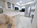 Open kitchen with white cabinets, stainless steel fridge, and seating at the island at 17404 N 99Th Ave # 126, Sun City, AZ 85373