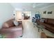 Inviting living room featuring tile flooring, leather furniture, and an open floor plan leading to the dining area at 17404 N 99Th Ave # 126, Sun City, AZ 85373