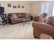 Cozy living room featuring tile flooring, leather furniture, and natural light at 17404 N 99Th Ave # 126, Sun City, AZ 85373
