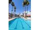 A swimming pool featuring palm trees, residential buildings, lounge chairs and patio umbrellas at 17404 N 99Th Ave # 126, Sun City, AZ 85373
