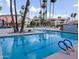 Inviting community pool with tall palm trees, lane dividers, and plenty of seating at 17404 N 99Th Ave # 126, Sun City, AZ 85373