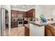 Efficient kitchen featuring dark wood cabinetry, stainless steel appliances, and a breakfast bar at 17649 W Buchanan St, Goodyear, AZ 85338