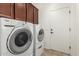 Laundry room featuring a stacked washer and dryer, upper cabinetry, and tile flooring at 17649 W Buchanan St, Goodyear, AZ 85338