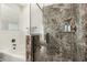 Modern shower with glass enclosure and gray tile with built-in soap and shampoo niche at 17649 W Buchanan St, Goodyear, AZ 85338