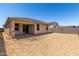A covered patio extending from the new home offers a view of the backyard space at 18354 W Patrick Ln, Surprise, AZ 85387