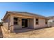A covered patio extends from the new home into the backyard space, awaiting landscaping at 18354 W Patrick Ln, Surprise, AZ 85387