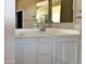 Bathroom showcasing a double sink vanity with white cabinets and a large mirror at 18354 W Patrick Ln, Surprise, AZ 85387