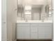 Bathroom with white double sink vanity, large mirror and wood-look floors at 18354 W Patrick Ln, Surprise, AZ 85387