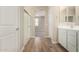 Bathroom boasts modern white vanity, and wood-look floors, leading to carpeted bedroom at 18354 W Patrick Ln, Surprise, AZ 85387