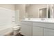 Bathroom featuring shower-tub combo, white vanity, and wood-look floors at 18354 W Patrick Ln, Surprise, AZ 85387