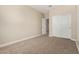 Bedroom featuring plush carpet, closet doors, and an ensuite bathroom at 18354 W Patrick Ln, Surprise, AZ 85387