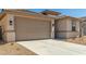 Tan single-Gathering home with a two-car garage and low-maintenance landscaping at 18354 W Patrick Ln, Surprise, AZ 85387
