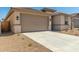 Tan single-Gathering home with a two-car garage and low-maintenance landscaping at 18354 W Patrick Ln, Surprise, AZ 85387