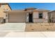 Tan single-Gathering home with a two-car garage and low-maintenance landscaping at 18354 W Patrick Ln, Surprise, AZ 85387
