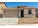 Tan single-Gathering home with a two-car garage and low-maintenance landscaping at 18354 W Patrick Ln, Surprise, AZ 85387