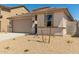 Tan single-Gathering home with a two-car garage and low-maintenance landscaping at 18354 W Patrick Ln, Surprise, AZ 85387