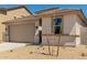 Tan single-Gathering home with a two-car garage and low-maintenance landscaping at 18354 W Patrick Ln, Surprise, AZ 85387