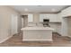 Bright kitchen features white cabinets, stainless steel appliances, and a large center island with counter seating at 18354 W Patrick Ln, Surprise, AZ 85387