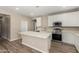 Bright kitchen features white cabinets, stainless steel appliances, and a large center island with counter seating at 18354 W Patrick Ln, Surprise, AZ 85387