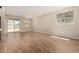 Open-concept living room featuring wood-look tile floors, neutral walls, and sliding door access at 18354 W Patrick Ln, Surprise, AZ 85387