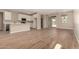 Open-concept living room flows into the kitchen, featuring wood-look tile floors at 18354 W Patrick Ln, Surprise, AZ 85387