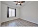 Well-lit bedroom featuring hardwood floors, a ceiling fan, and a large window at 21833 N 34Th Ave, Phoenix, AZ 85027