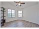 This sunlit bedroom features wood-look floors, large windows, and a ceiling fan at 21833 N 34Th Ave, Phoenix, AZ 85027