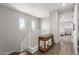 Bright hallway with wood floors, white railing, and views into a bedroom with a white bed frame at 2371 W Whisper Rock Trl, Phoenix, AZ 85085