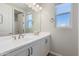 Bathroom featuring double sinks with white countertops, modern fixtures, and a window with blinds at 24533 N 19Th Ter, Phoenix, AZ 85024