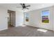 A bedroom with neutral carpet, windows, and door to a bathroom at 24533 N 19Th Ter, Phoenix, AZ 85024