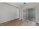 Open-concept living room featuring wood-look tile flooring, neutral walls, and a sliding glass door at 24533 N 19Th Ter, Phoenix, AZ 85024