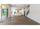 Open living space with tile flooring, leading into a bright kitchen with white cabinets and modern appliances at 24533 N 19Th Ter, Phoenix, AZ 85024