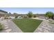 Lush backyard featuring plush green grass, desert landscaping, and a cozy fire pit area at 2514 E Pleasant Ln, Phoenix, AZ 85042