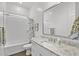 Bright bathroom with a white subway tiled shower and tub, granite countertop, and gray framed mirror at 2514 E Pleasant Ln, Phoenix, AZ 85042