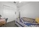 Bedroom featuring carpet, white walls, a ceiling fan, a window, and a gray bed frame with blue floral bedding at 2514 E Pleasant Ln, Phoenix, AZ 85042