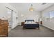 Serene bedroom with neutral tones, stylish light fixture, and a barn door leading to the ensuite bathroom at 2514 E Pleasant Ln, Phoenix, AZ 85042