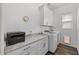 Bright laundry room with white cabinets, granite countertops, a window, and new washer and dryer at 2514 E Pleasant Ln, Phoenix, AZ 85042