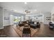 Bright, open-concept living room with wood floors, a large sectional sofa, and sliding doors to the backyard at 2514 E Pleasant Ln, Phoenix, AZ 85042