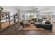 Bright living room featuring hardwood floors, a comfy gray sofa, and an open layout to the dining and kitchen areas at 2514 E Pleasant Ln, Phoenix, AZ 85042
