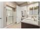 Bathroom featuring a walk-in shower, double sinks, and view to the main bedroom at 26161 W Siesta Ln, Buckeye, AZ 85396