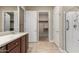 Bathroom with walk-in shower, updated cabinets, and a doorway to the walk-in closet at 26161 W Siesta Ln, Buckeye, AZ 85396