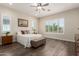 Spacious bedroom with wood floors, natural light, ceiling fan, and a cozy sitting bench at 26161 W Siesta Ln, Buckeye, AZ 85396
