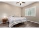 Inviting bedroom showcasing wood floors, ceiling fan, and bright, shuttered window at 26161 W Siesta Ln, Buckeye, AZ 85396