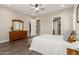 Bright bedroom featuring wood floors, ceiling fan, natural light, and a wooden dresser at 26161 W Siesta Ln, Buckeye, AZ 85396
