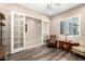 Well-lit living room with glass French doors, accent chair, and wood flooring at 26161 W Siesta Ln, Buckeye, AZ 85396