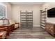 Cozy Living room offering built-in shelving, wood floors, and natural light from shuttered windows at 26161 W Siesta Ln, Buckeye, AZ 85396