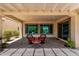Cozy covered patio with wicker furniture and views of lush greenery at 26161 W Siesta Ln, Buckeye, AZ 85396